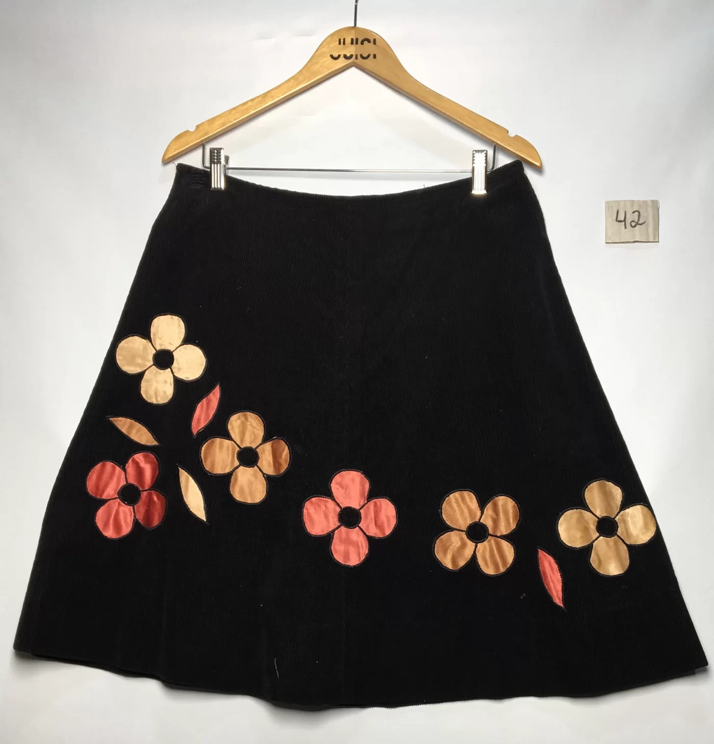 SAIA EM VELUDO COTELE PRETO COM APLICACOES DE FLORES ACETINADAS