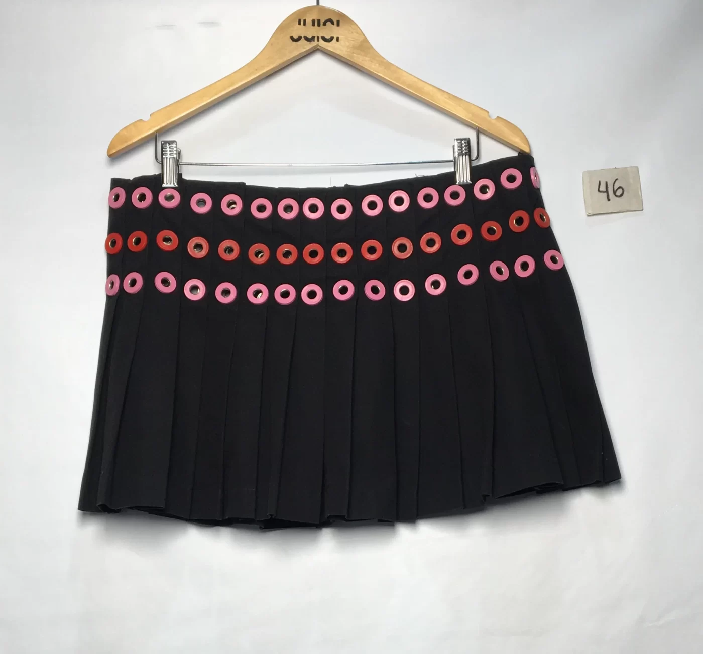 MINISSAIA PRETA COM PREGAS DETALHE DE ILHÓS VERMELHO E ROSA